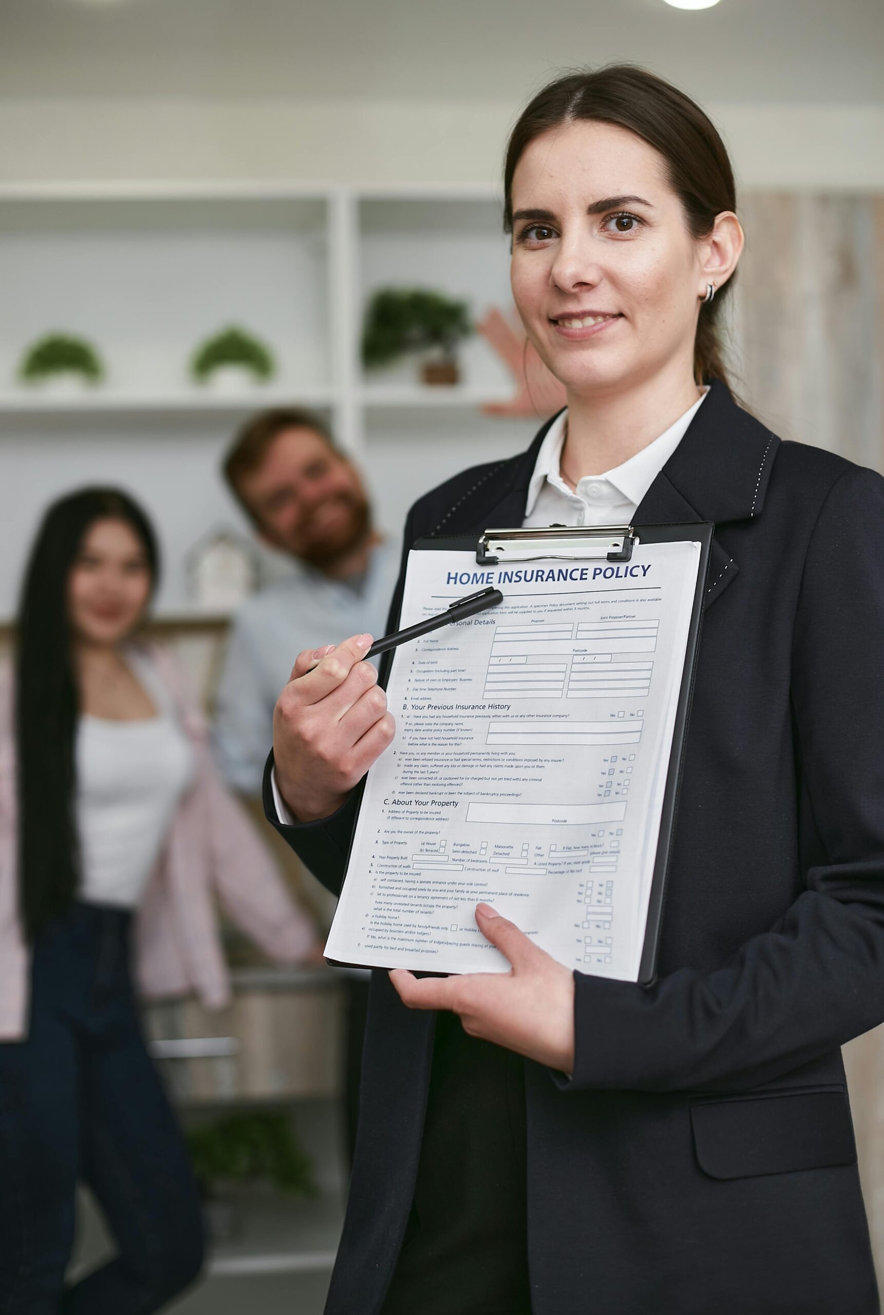 Contract Drafting Review and Para Legal Confident businesswoman presenting a home insurance policy indoors to potential clients.